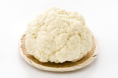 Beyaz arka planda bambu elek üzerinde taze karnabahar.