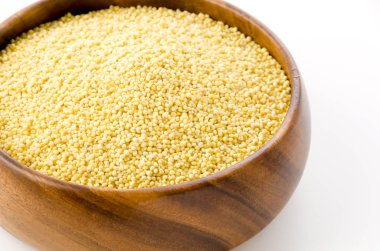 Yuvarlak ahşap kasede beyaz arka planda yapışık Millet