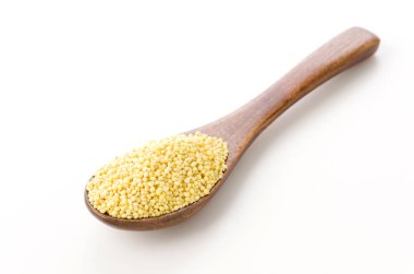 Beyaz arka planda ahşap kaşıkla yapışık Millet