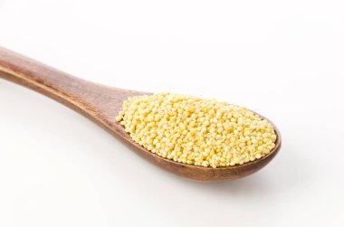 Beyaz arka planda ahşap kaşıkla yapışık Millet