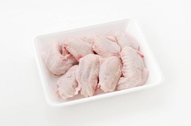 Beyaz plastik bir kabın içinde çiğ ve çiğ tavuk kanadı.