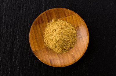 Tahta tozda kimyon Siyah taş plaka üzerinde küçük tabak