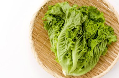 Beyaz arka planda taze yeşil marul ve bambu kevgiri.
