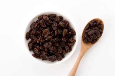 Kuru üzümler beyaz arkaplanda küçük tabakta