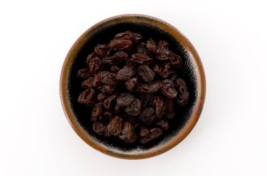 Beyaz arkaplanda küçük bir tabakta kuru üzümler