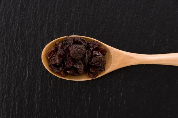 Raisins Dans Une Cuillère Bois Sur Fond Pierre Noire — Photo