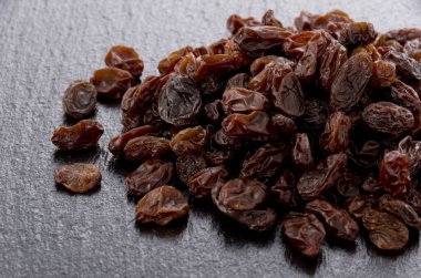 Siyah taş zemin üzerinde kuru üzüm