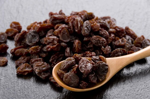 Raisins Wooden Spoon Black Stone Background — Stock Photo, Image