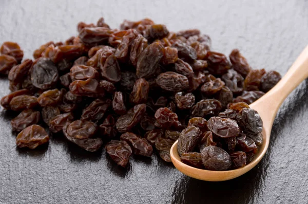 Raisins Wooden Spoon Black Stone Background — Stock Photo, Image