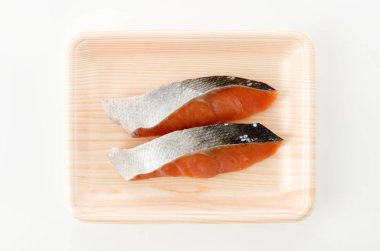 Beyaz arka planda köpük tepside somon fileto.