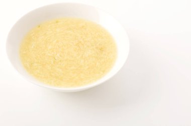 Beyaz tabakta tatlı mısır yumurtası çorbası