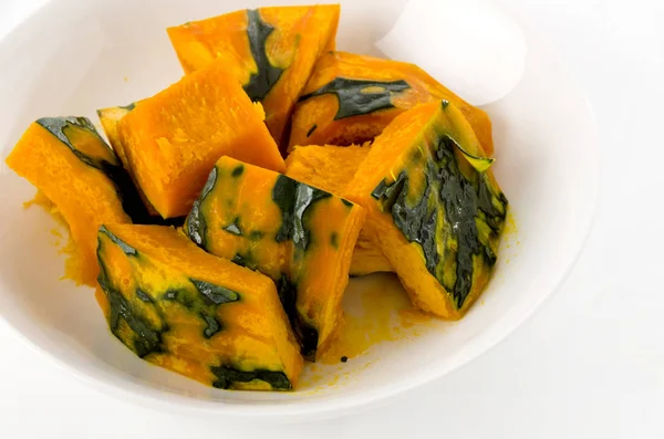 Steamed pumpkin  on a white round dish on white background