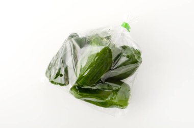 Beyaz arka planda plastik poşette dolma biber.