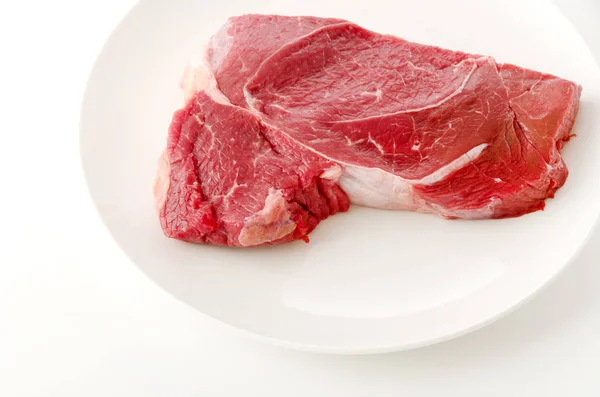 Beyaz Arka Planda Bir Tabakta Yuvarlak Biftek — Stok fotoğraf