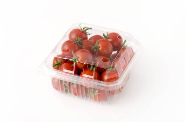 Plastik bir kap içinde kiraz domates. Beyaz arka plan üzerinde kutusunda taze kiraz domates.