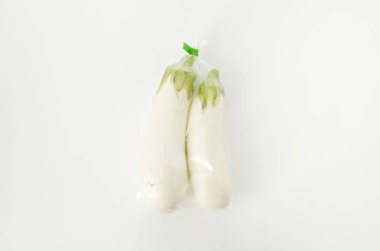 Beyaz arka planda plastik poşette beyaz patlıcan