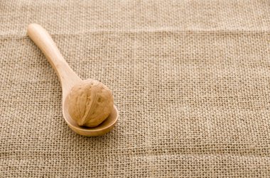 Çuval arka plan üzerinde tahta bir kaşık ceviz