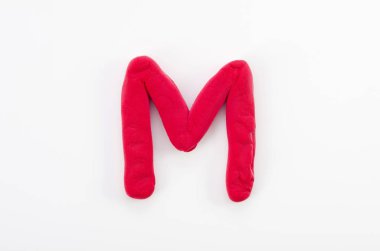 Beyaz arkaplanda izole edilmiş İngiliz alfabesinin M büyük harfi kırmızı plasticine.