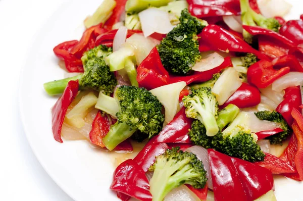 Kırmızı biber ve brokoli soğanını beyaz tabakta kızart.