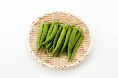 Beyaz arka planda bambu elek taze bamya