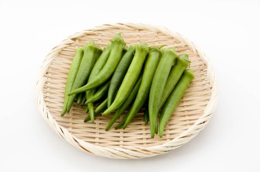 Beyaz arka planda bambu elek taze bamya