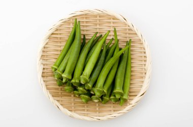 Beyaz arka planda bambu elek taze bamya