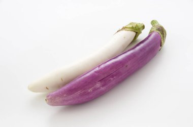 Beyaz arka planda uzun beyaz patlıcan ve uzun mor patlıcan.