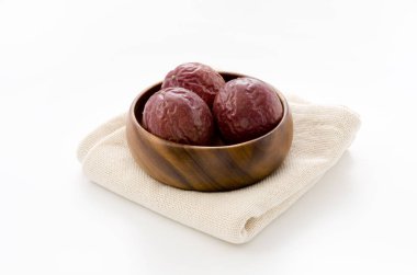 Yuvarlak ahşap kasede buğulanmış kumaş üzerinde tutku meyvesi.