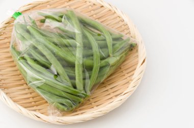 Bambu elek üzerinde plastik torba içinde fasulye.