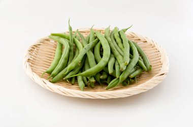 Beyaz arka planda bambu elek üzerindeki fasulye.