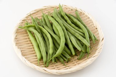 Beyaz arka planda bambu elek üzerindeki fasulye.