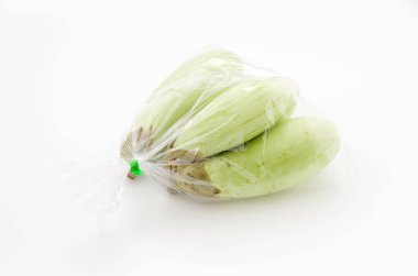 Beyaz arka planda plastik poşette yeşil patlıcan