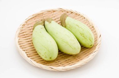 Bambu elek beyaz arka planda yeşil patlıcan