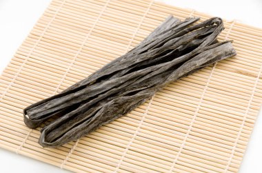 Kurutulmuş kombu yosunu Japon kuru yosunu bambu hasırı üzerinde.