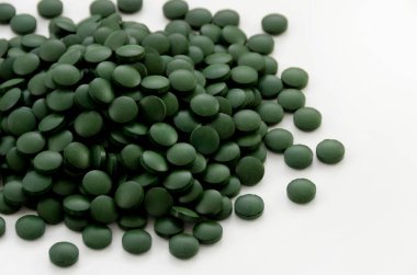 Beyaz arkaplanda yeşil haplar,