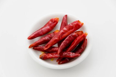 Beyaz arkaplanda izole edilmiş küçük kapsicum yıllık beyaz tabak.