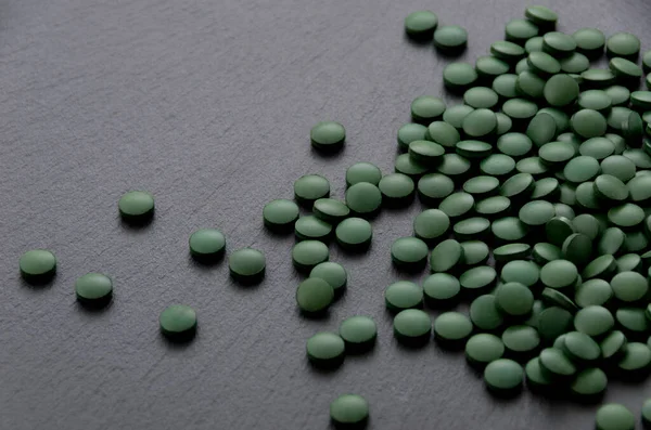 Zelené Pilulky Spirulina Tablety Černé Kamenné Desce — Stock fotografie