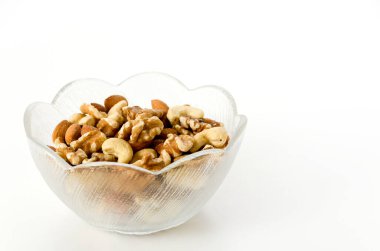 Beyaz arka planda cam bir kasede fındık karışımı.. 