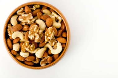 Beyaz arka planda ahşap bir kasede fındık karışımı. 