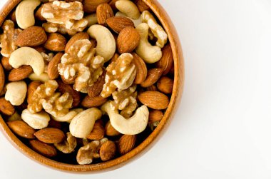 Beyaz arka planda ahşap bir kasede fındık karışımı. 