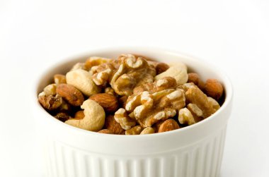 Beyaz arka planda bir cocotte içinde fındık karışımı. 