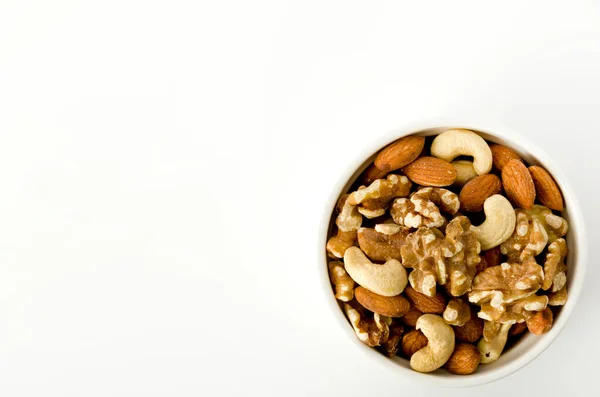 stock image mix of nuts in a cocotte on a white background. 