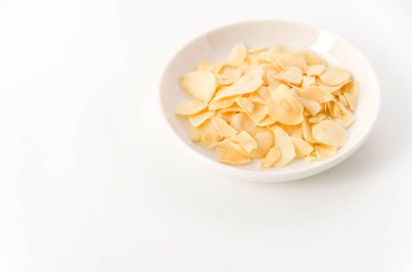 Küçük tabakta kurutulmuş sarımsak cipsi.