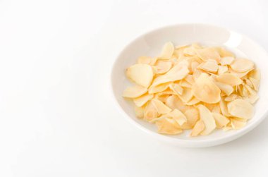 Küçük tabakta kurutulmuş sarımsak cipsi.