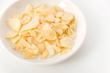 Küçük tabakta kurutulmuş sarımsak cipsi.