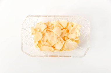 Küçük cam tabakta kurutulmuş sarımsak cipsi.