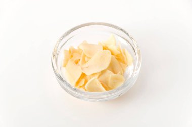 Beyaz arka planda istiflenmiş sarımsak cipsi.