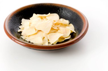 Küçük tabakta kurutulmuş sarımsak cipsi.