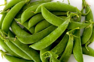 Beyaz arkaplanda şekerli bezelye. 