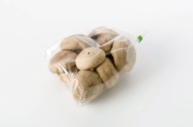 Beyaz arka planda şeffaf plastik torba içinde Shiitake mantarı